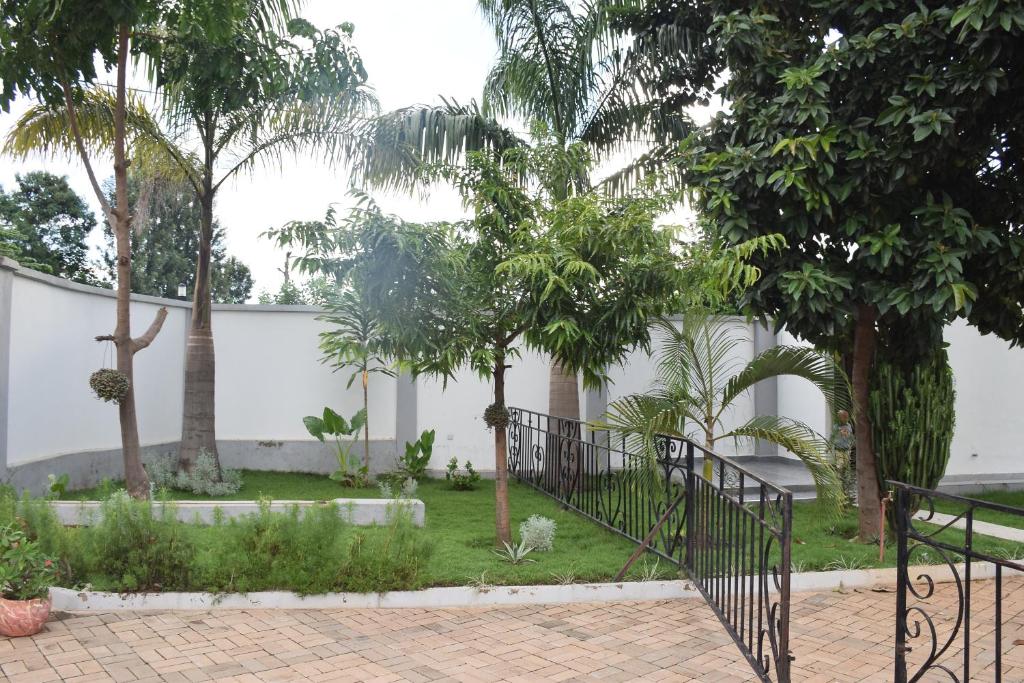 a courtyard with trees and a white fence at Beatrice James airbnb Moshi in Moshi