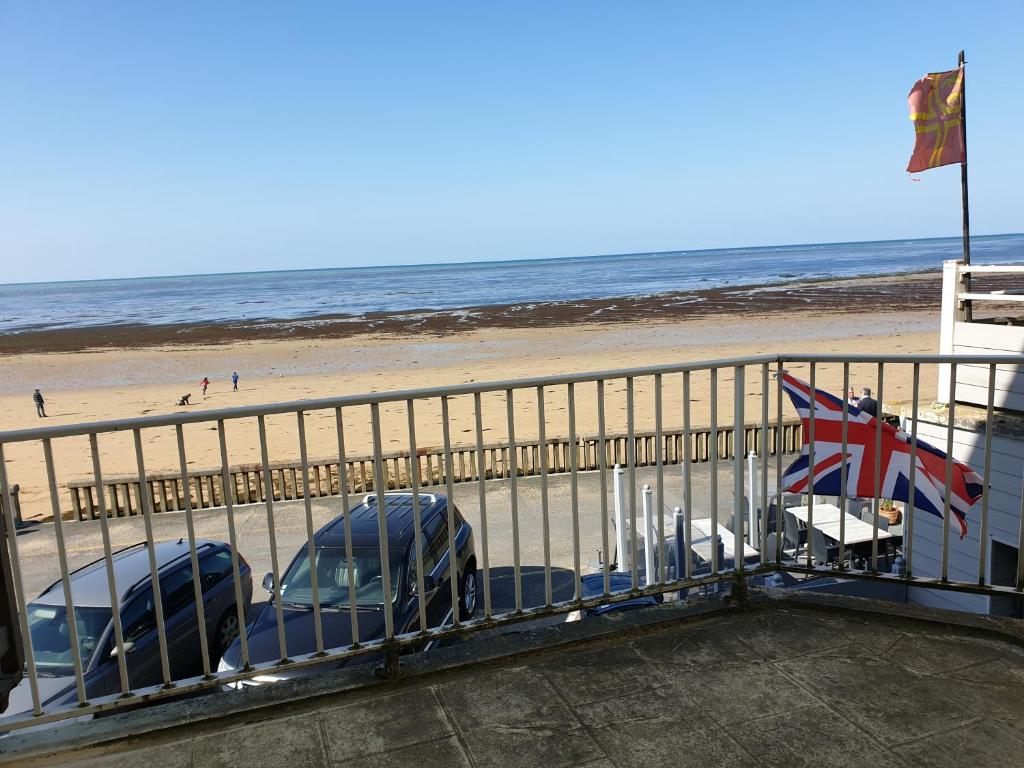 deux voitures garées sur une jetée à côté de la plage dans l'établissement Villa Familia, à Grandcamp-Maisy