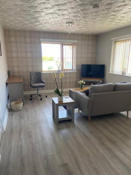 ein Wohnzimmer mit einem Sofa und einem Stuhl in der Unterkunft Olympic Place 1-bed Apartment in Rowley Regis