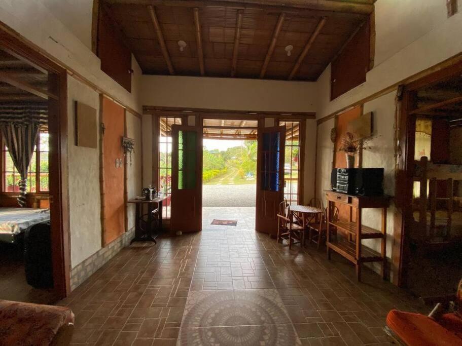 ein Wohnzimmer mit einem Zimmer mit einem Bett und einem Tisch in der Unterkunft Hermosa casa campestre in Popayan