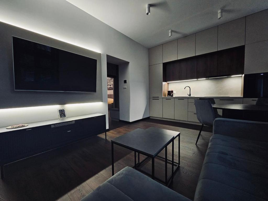 a living room with a large flat screen tv on a wall at Apartament Prestige in Nowy Sącz