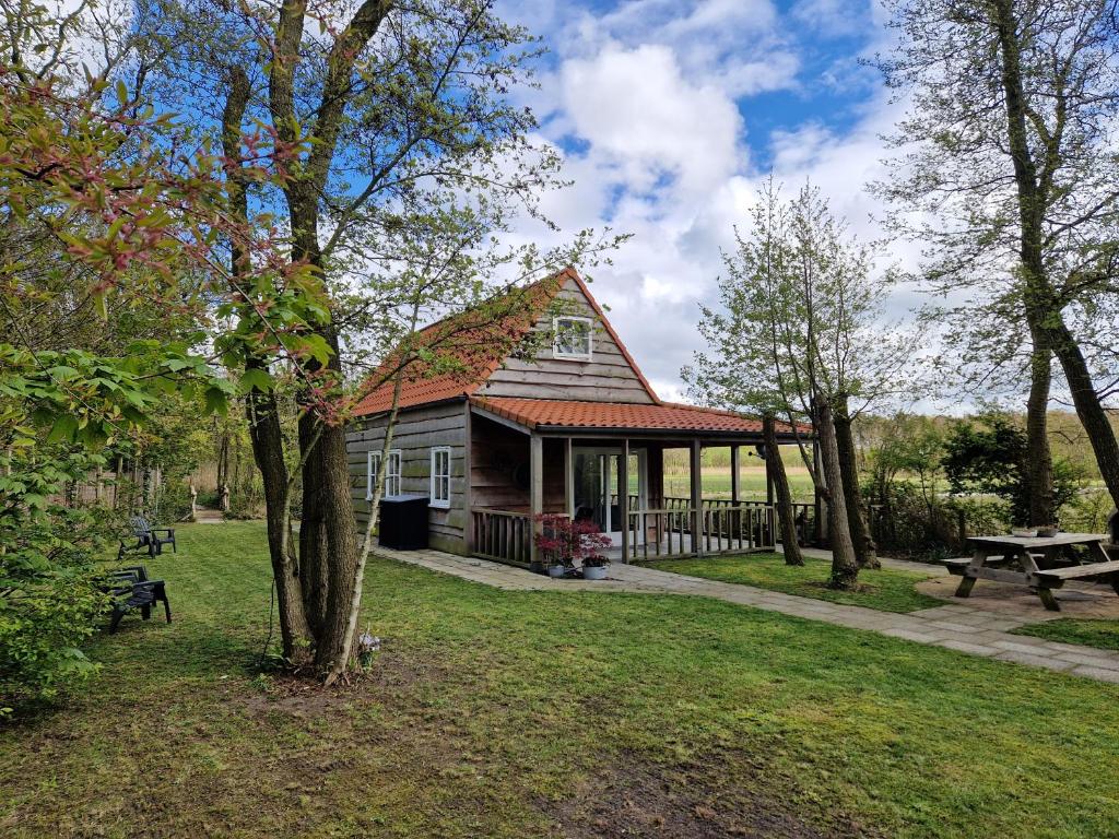 una casa con porche y mesa de picnic en Sea Jewel (voorheen Dromen aan Zee), en Callantsoog