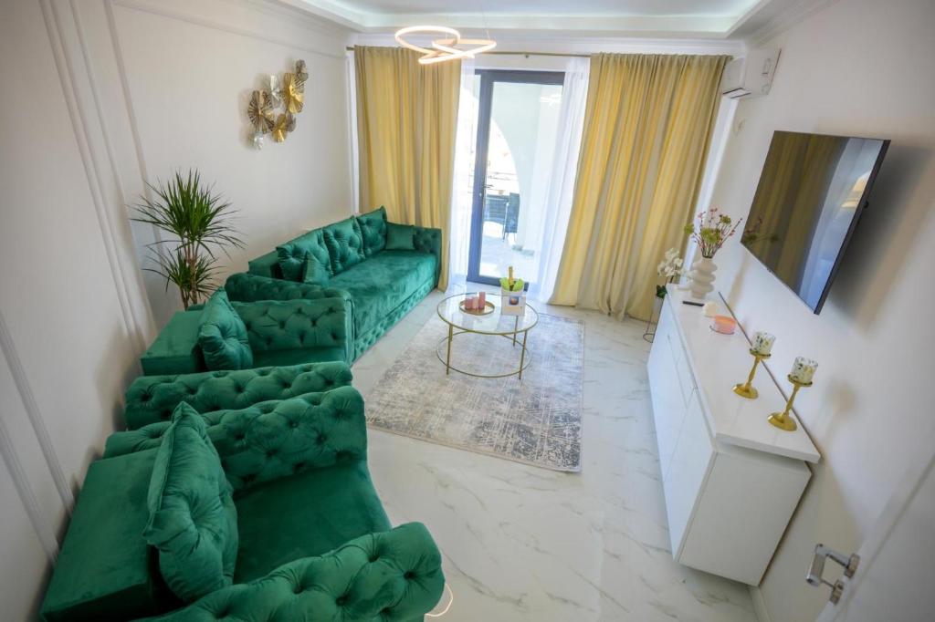 a living room with a green couch and a table at Apartament Zig Zag in Mamaia Nord