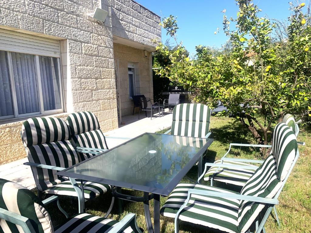 três cadeiras e uma mesa e uma mesa e cadeiras em Exclusive Jerusalem Villa em Giv‘ot Mordekhay