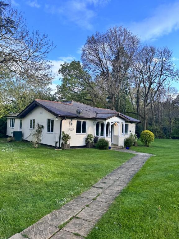 a white house with a grassy yard at Luxury Home with Gym/Outdoor play area - 40 mins from Luton/Stansted in Knebworth