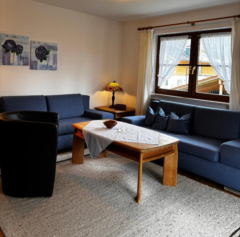 a living room with a blue couch and a coffee table at Ferienwohnung Claudia in Oberammergau