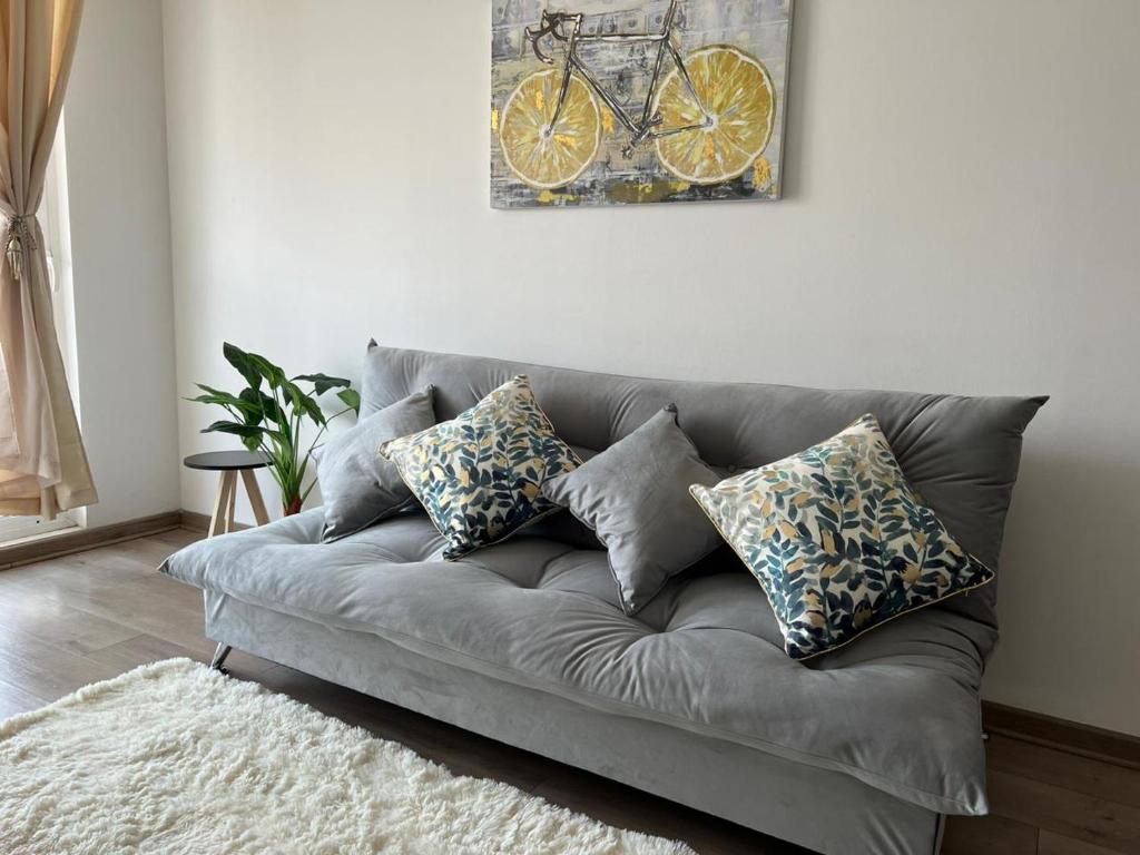 蘭卡瓜的住宿－Departamento AIRE Acondicionado de 3 Dormitorios ESTACIONAMIENTO y WIFI，客厅里一张灰色的沙发,墙上挂着自行车