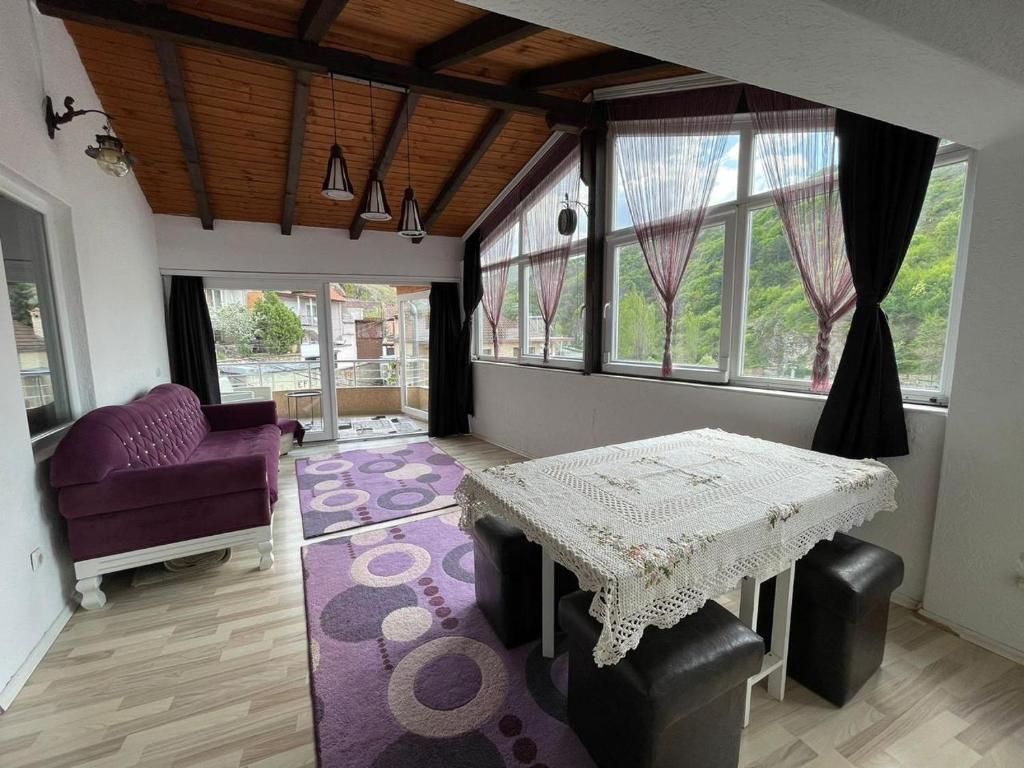 a living room with a table and a purple couch at Deni house in Prizren