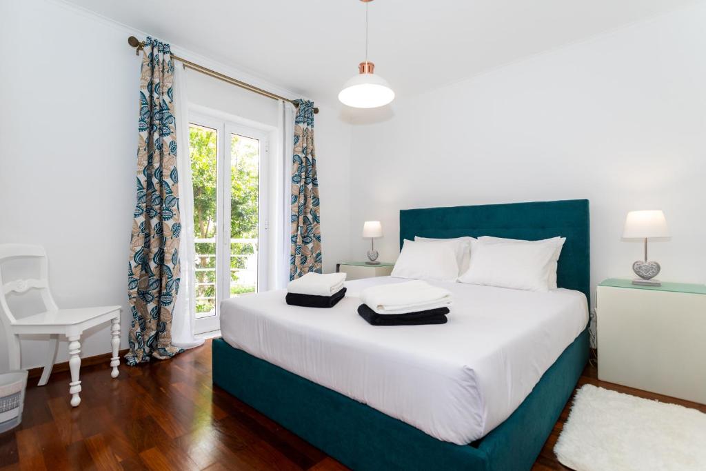 um quarto com uma grande cama branca e uma janela em Mónaco Nest em Ponta Delgada
