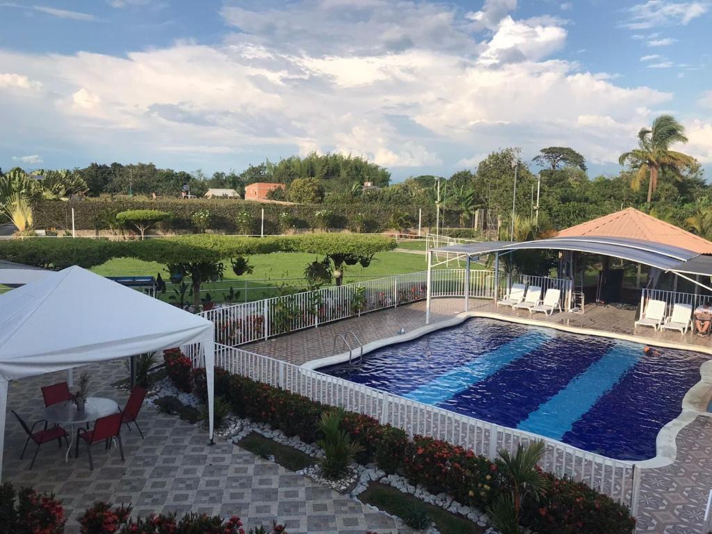 a swimming pool with a gazebo next to at Finca Lujosa con Hermosa Piscina in Palmira