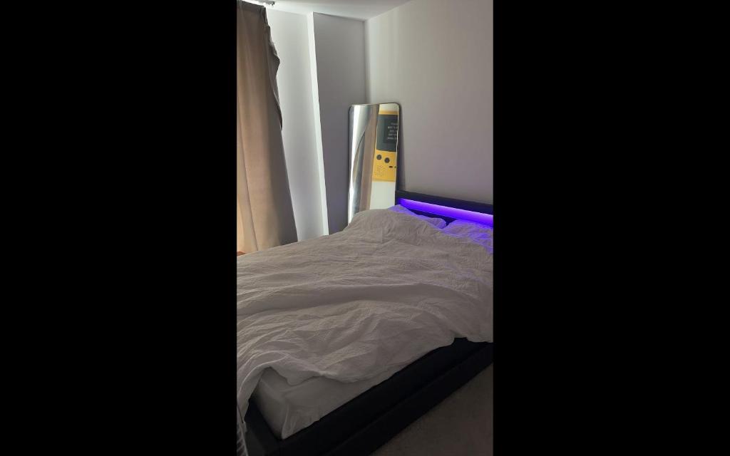 a small bed in a room with purple lighting at TMW stays in London