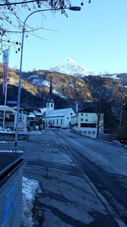 an empty street with a church and a mountain at Studio "Chüngelhoschet" in Näfels