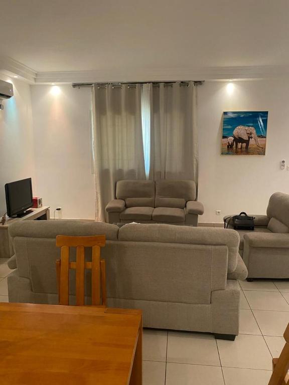 APPHIA SERVICES في بوانت نوار: غرفة معيشة مع أريكة وكرسيين