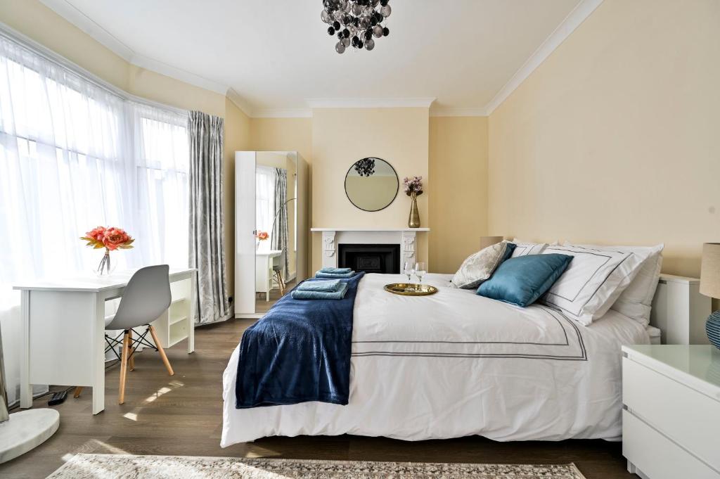 1 dormitorio con 1 cama grande y escritorio en Greenwich Holiday Home, en Londres