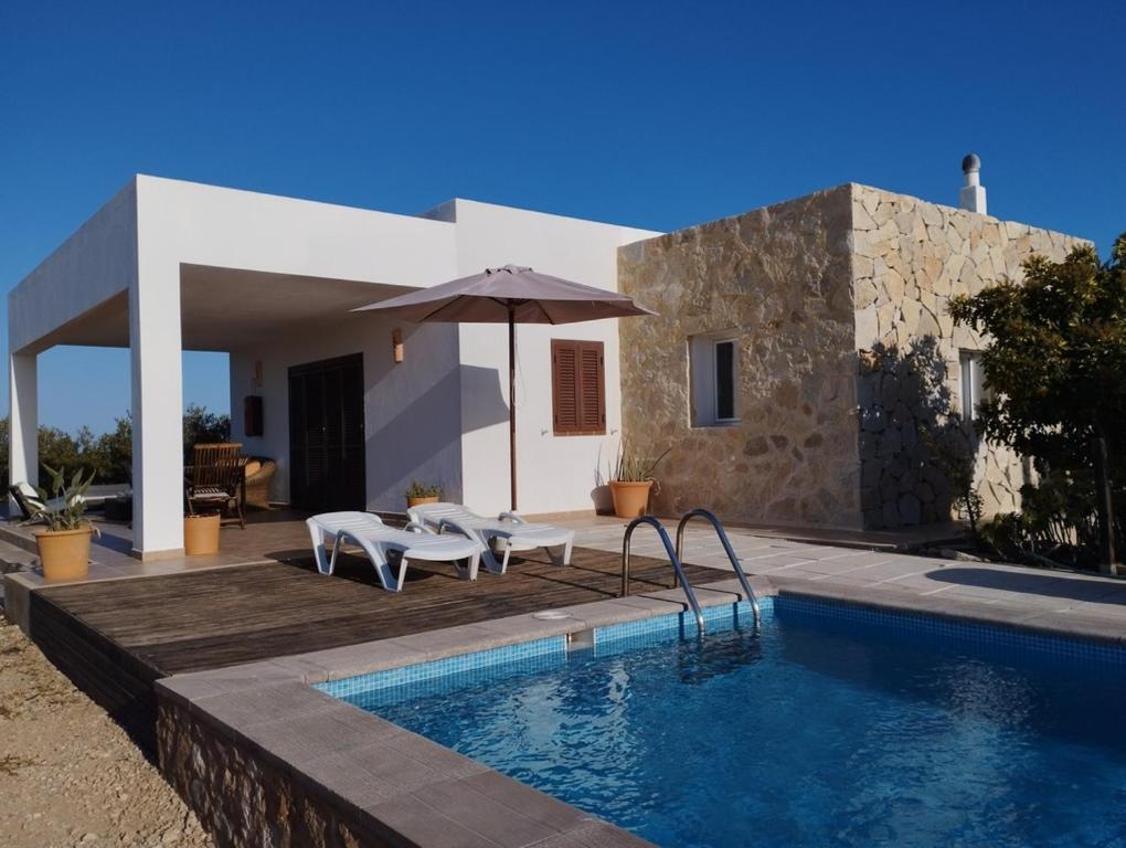 a villa with a swimming pool and a house at VILLA Can Guillem d'es Puig in Sant Francesc Xavier