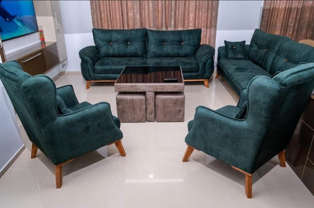 uma sala de estar com um sofá e duas cadeiras e uma mesa em Hotel Luka em Ureki