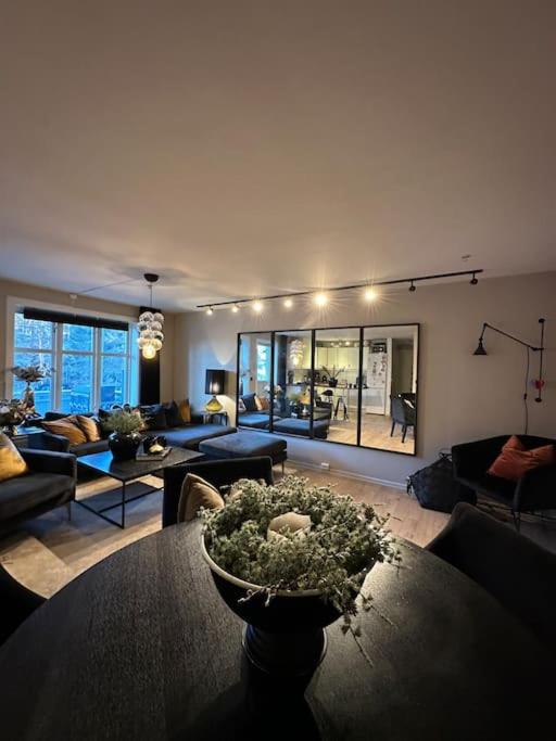 a living room with a vase of flowers on a table at romslig leilighet til leie in Arendal