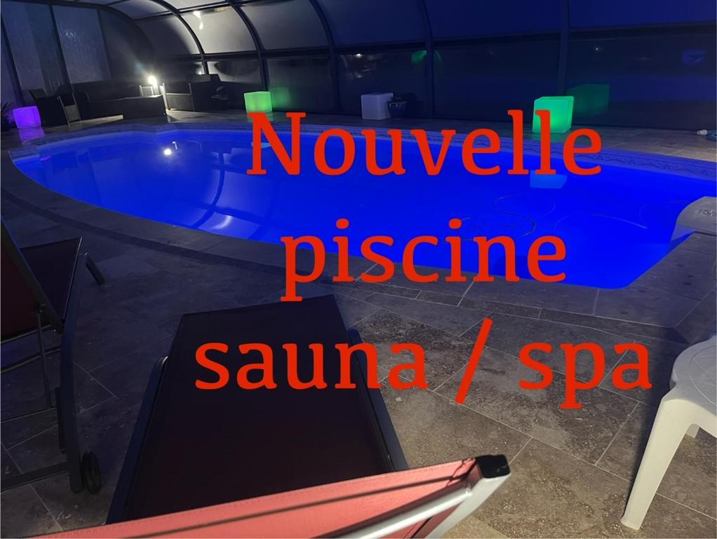a swimming pool at night with the words noelle gesture sauna spa at Studio spa privé accès piscine in Moëlan-sur-Mer