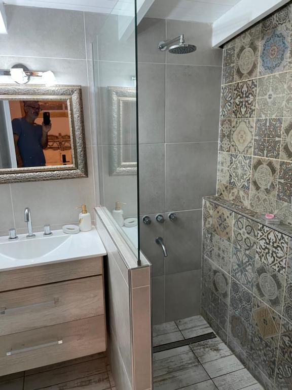 a bathroom with a shower and a sink and a mirror at Casa Monte in Monte Hermoso
