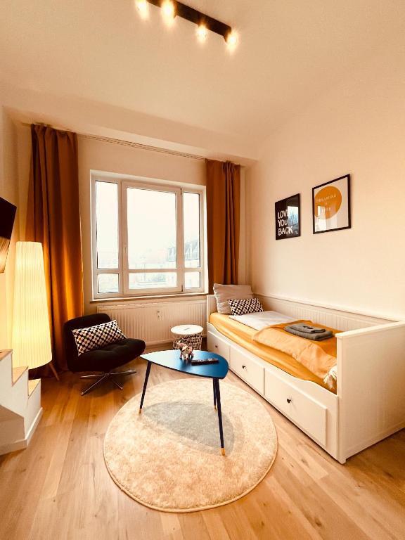 ein Schlafzimmer mit einem großen Bett und einem Tisch in der Unterkunft D52 - das Businessapartment in Dresden