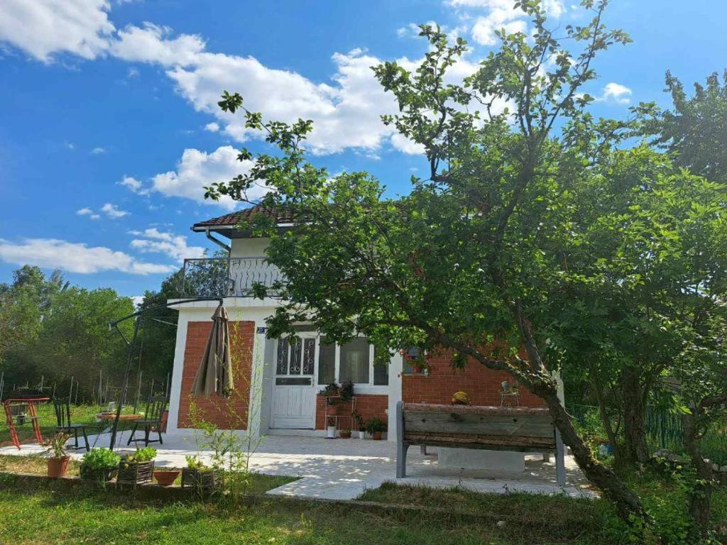 a small house with a bench in front of it at Guest house Green River in Ljubuški