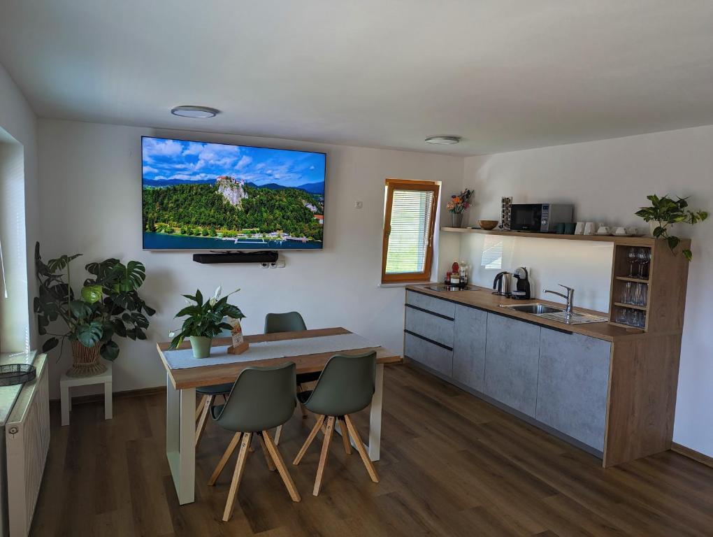 a kitchen with a table and a tv on the wall at Studio apartment Velis in Radovljica