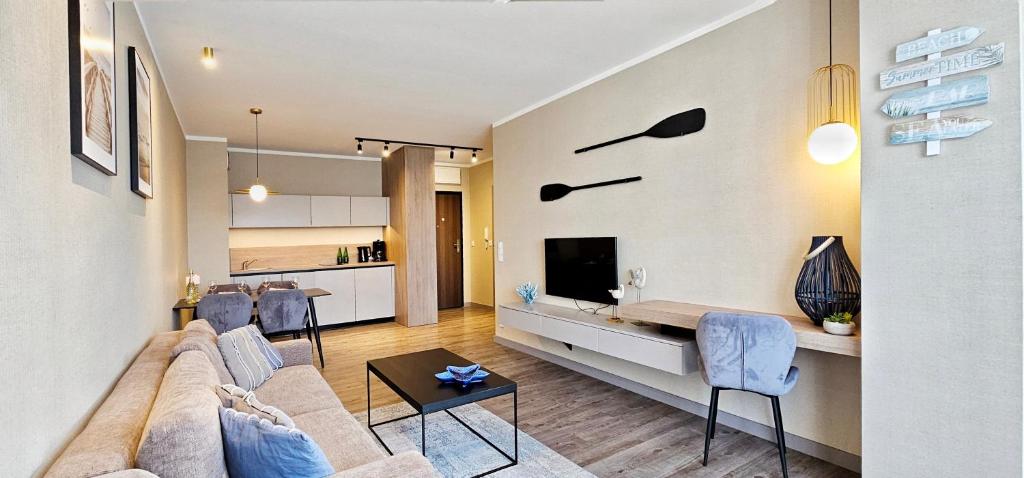 米兹多洛杰HolidayHomePL Bel Mare 317e z balkonem的客厅里有一张沙发和一张桌子。