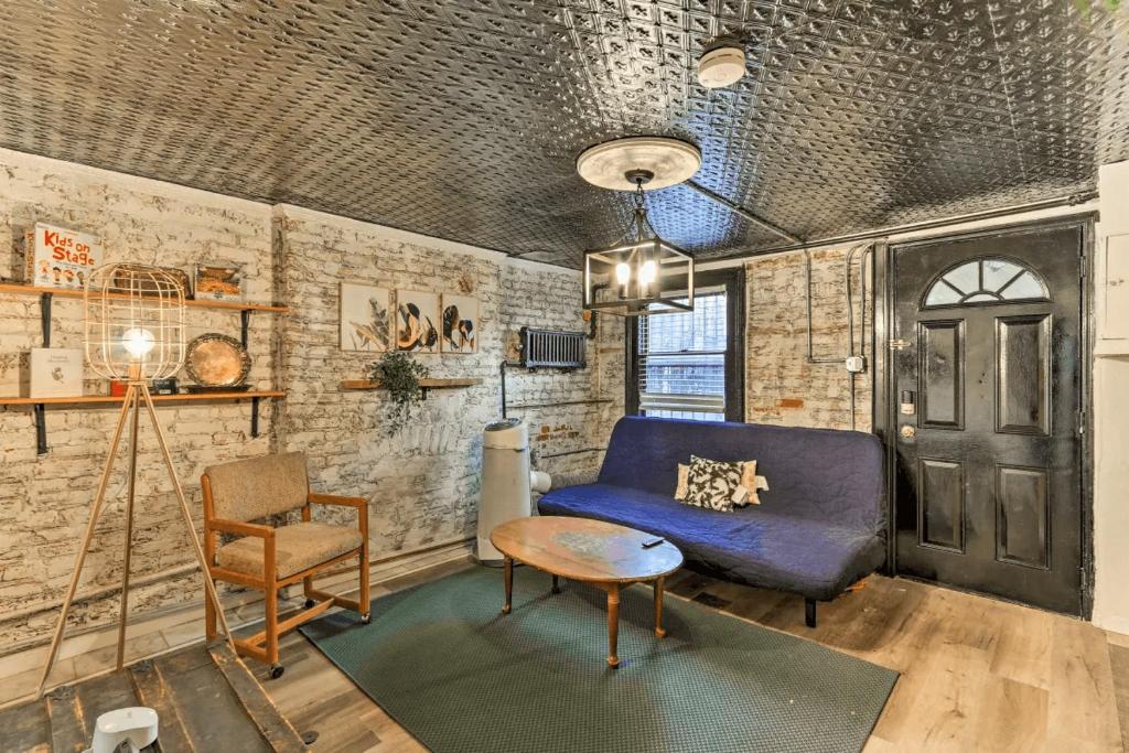 a living room with a blue couch and a chair at 1850s historic Row House 7min train to NYC with private backyard in Jersey City