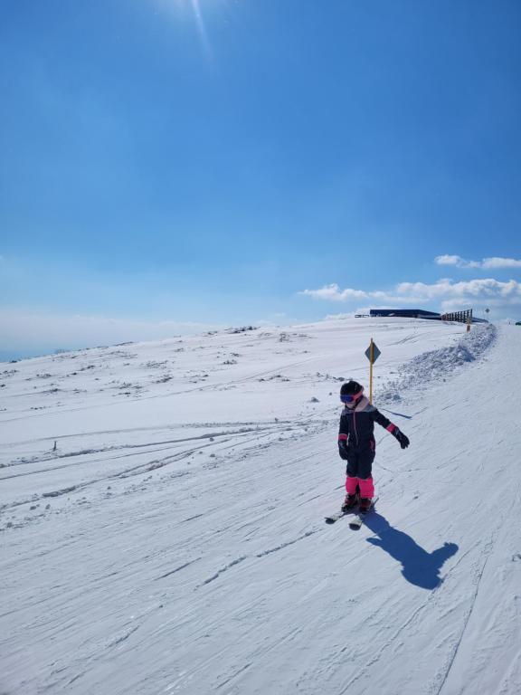 a child is standing on skis in the snow at KUĆA OSMEHA KALNA in Kalna
