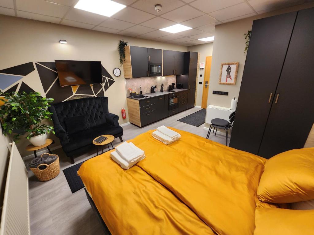 Zimmer mit einem großen gelben Bett und einer Küche in der Unterkunft Base apartments - capital area in Hafnarfjördur