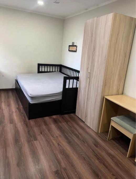 a small bedroom with a bed and a wooden floor at Unique Studio Flat in City Center in Leicester