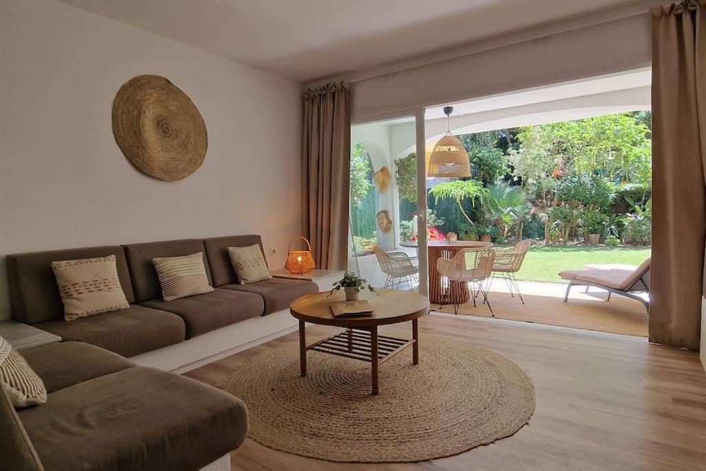een woonkamer met een bank en een tafel bij Luxe studio met ruim terras, vlak aan zee! in Sitio de Calahonda