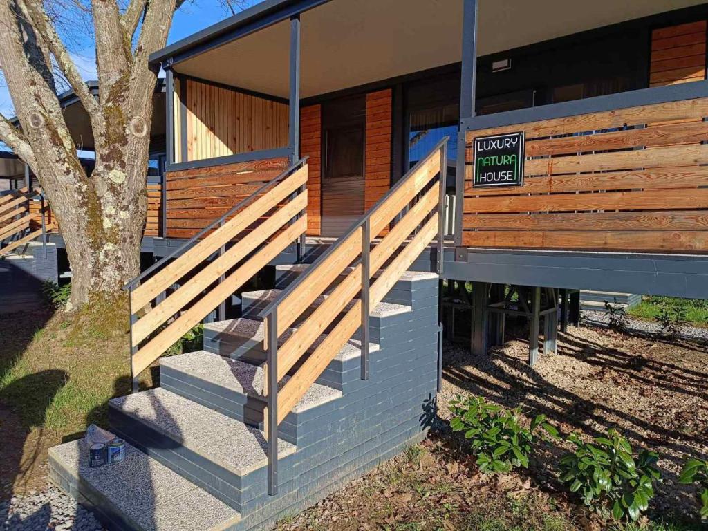 un bâtiment avec des escaliers en bois et un panneau sur celui-ci dans l'établissement KOLPA - Luxury Natura House, à Gradac