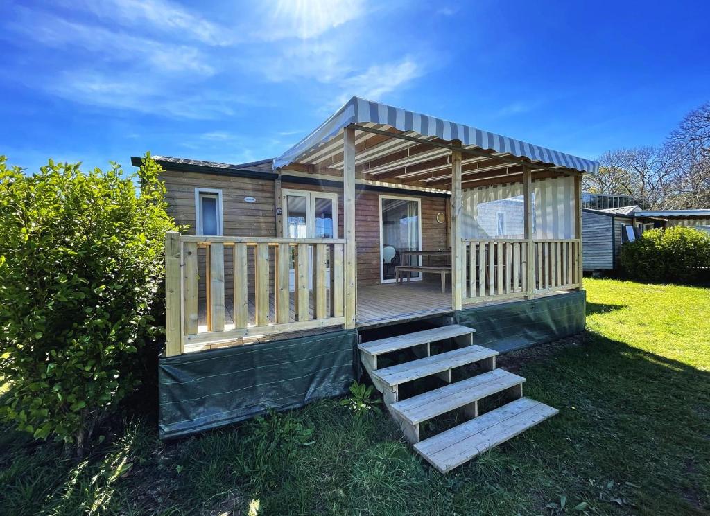 a tiny house with a staircase in the yard at Bungalow Breizh Vue in Plouha