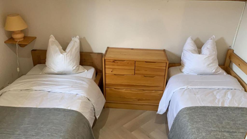 1 dormitorio con 2 camas y tocador de madera en Appartement de montagne, en Bernex