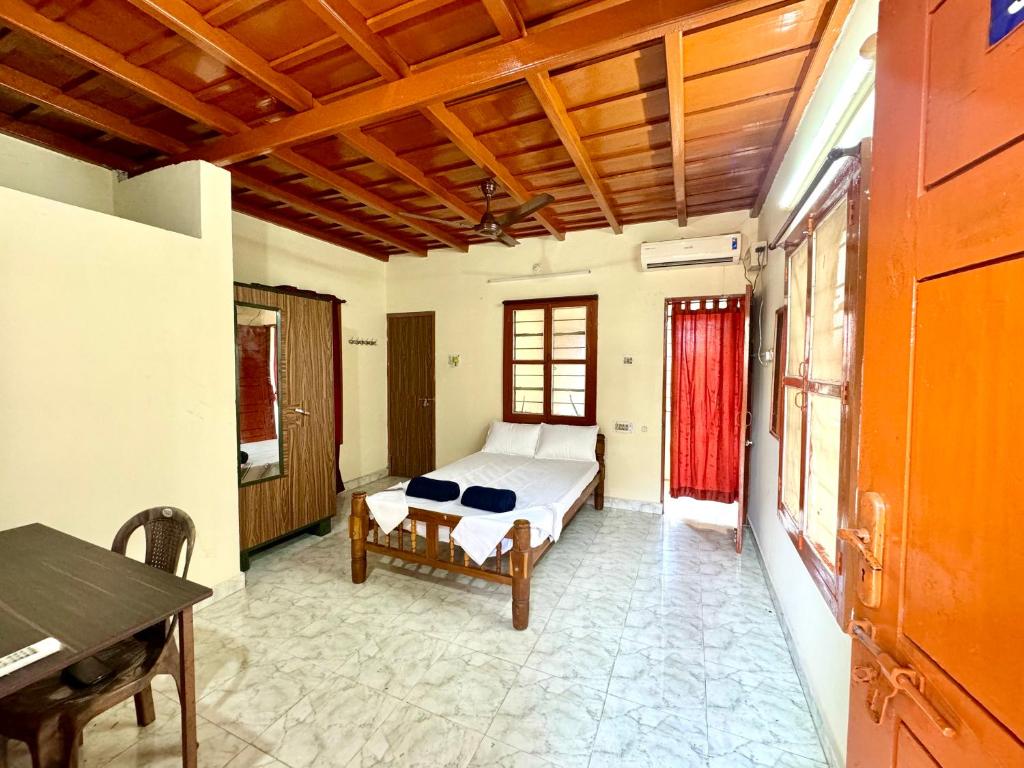 a bedroom with a bed and a table in it at Acharya Compound in Udupi