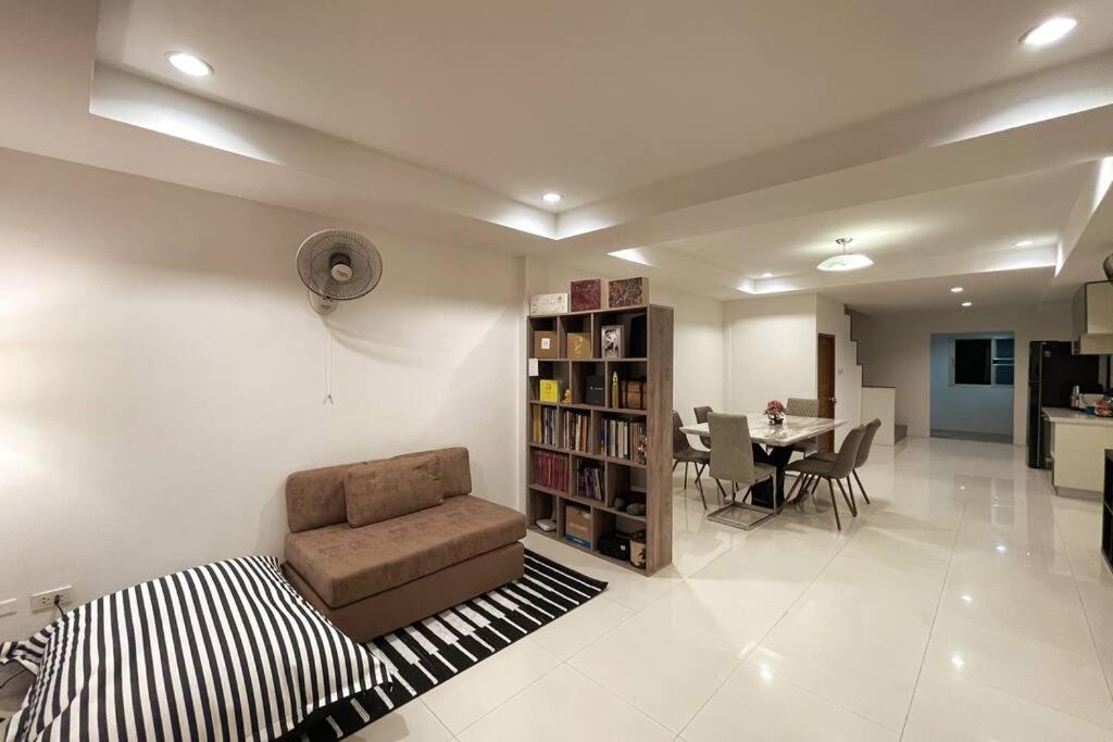 a living room with a chair and a book shelf at Cozy&Beach House-2BRs, Beach, Walking St, Pier in Pattaya South