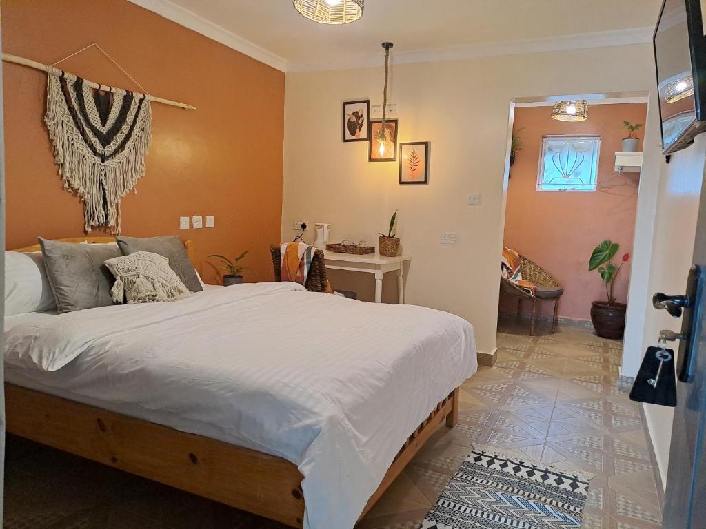 a bedroom with a large bed and a table at The Yala Home in Eldoret