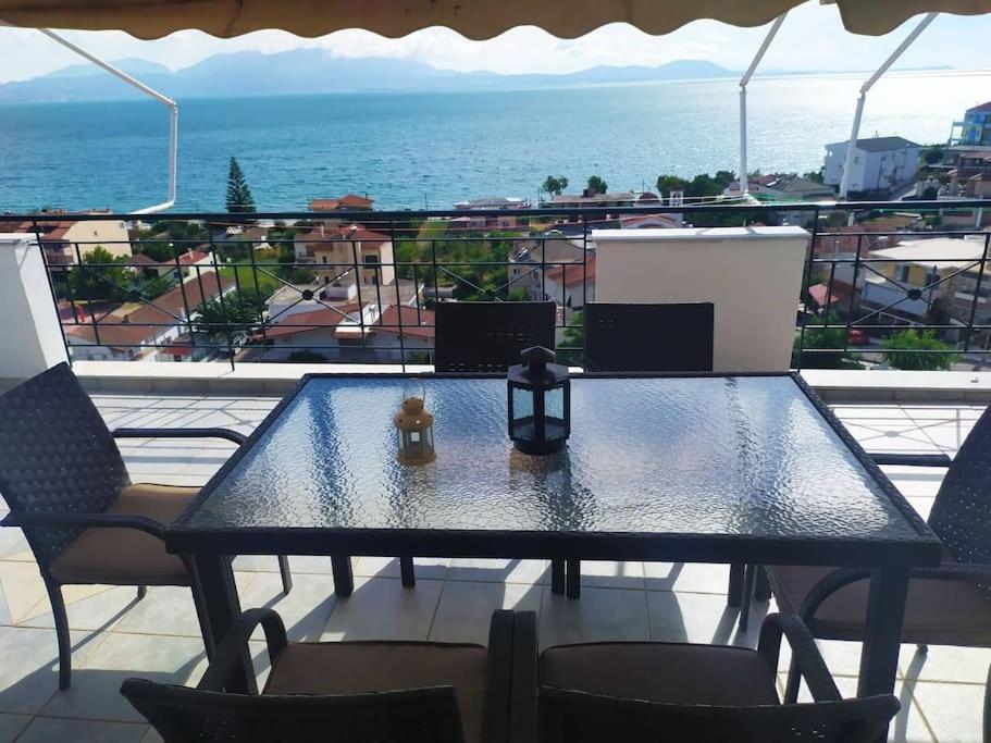 uma mesa com uma vela numa varanda com o oceano em Όμορφο διαμέρισμα με εκπληκτική θέα em Menídion