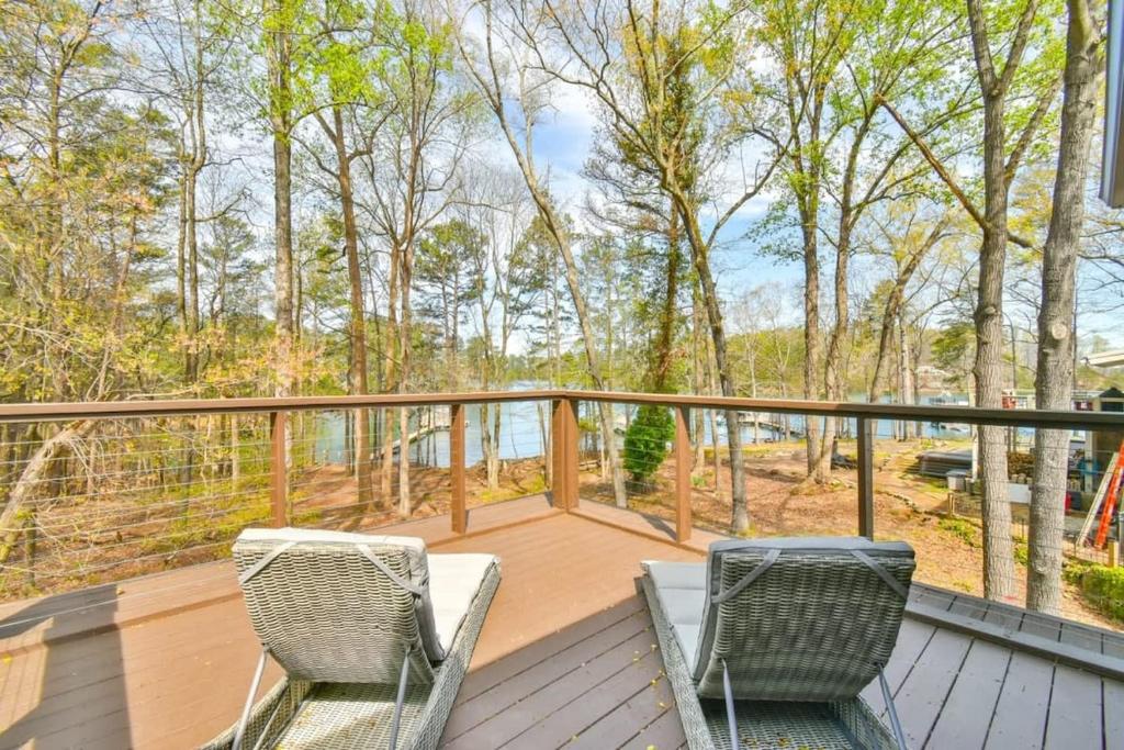 una terraza con 2 sillas y vistas al agua en Luxurious Lake Lanier Home with Private Dock, en Flowery Branch