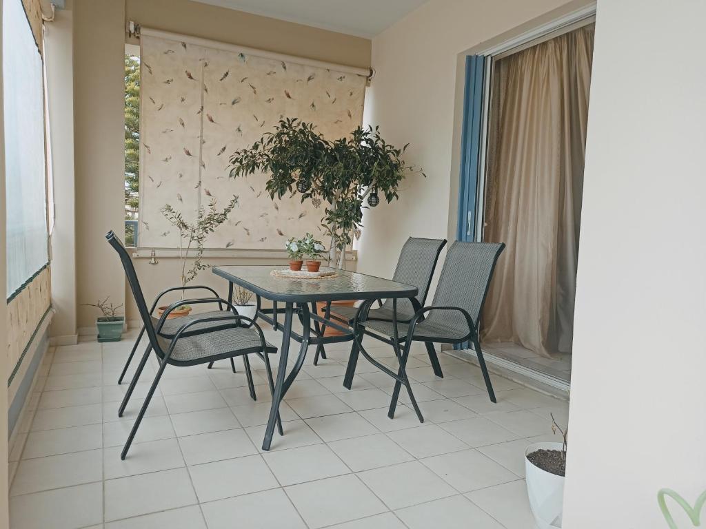 a table and chairs sitting on a balcony at Nefeli's Home- Family luxury apartment in Heraklio Town