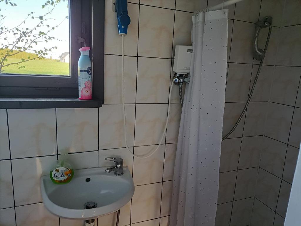 La salle de bains est pourvue d'un lavabo et d'une fenêtre. dans l'établissement domek good vibes A, à Gnieżdżewo