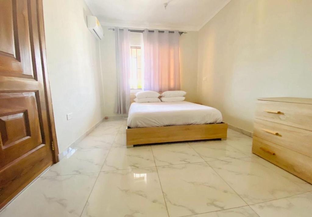 a bedroom with a bed with two pillows on it at Ferrez Apartment in Accra
