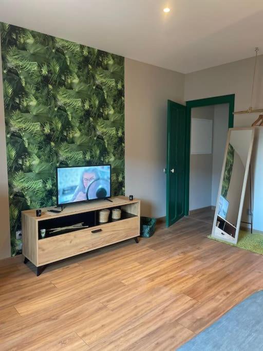 un salon avec une grande fresque verte sur le mur dans l'établissement Welcome to the Jungle !, à Saint-Dizier