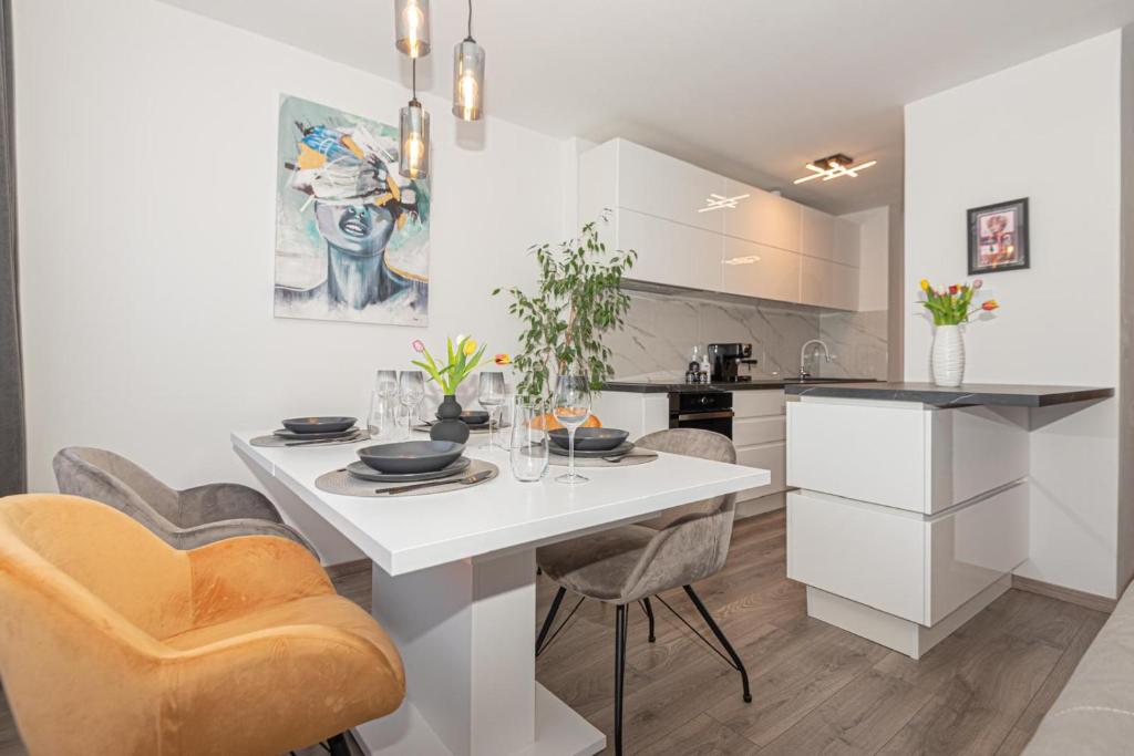 a kitchen with a white table and chairs at Apartman Holiday in Šibenik