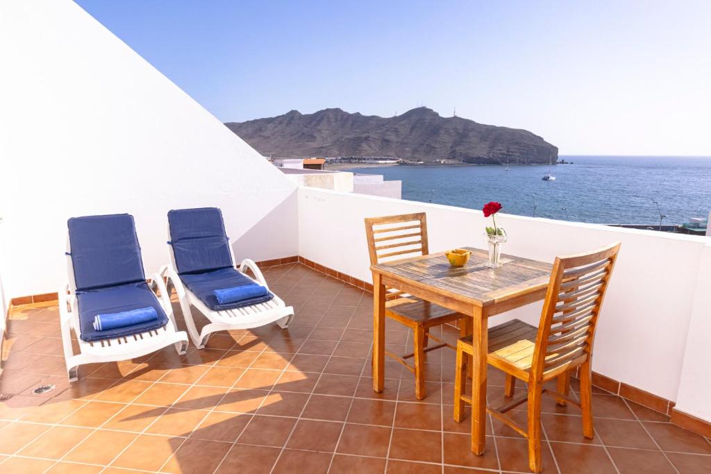 balcón con mesa, sillas y vistas al océano en Apartamento junto el mar, en Gran Tarajal