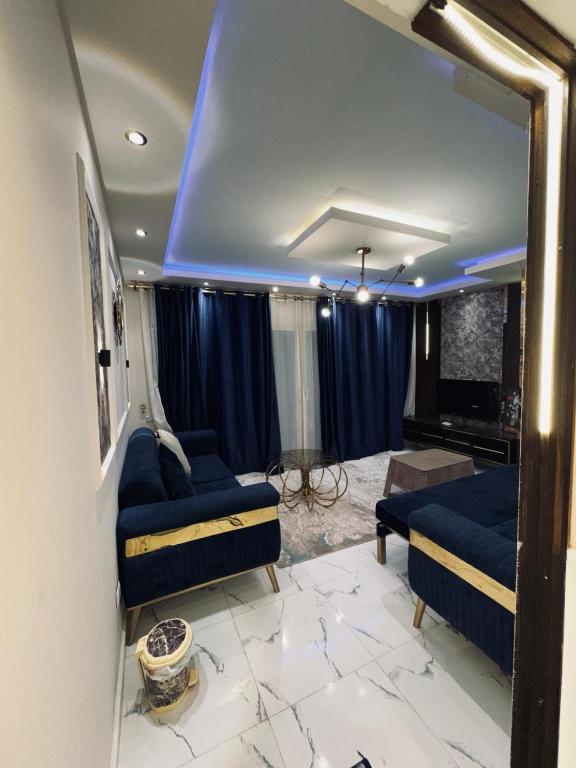 ein Wohnzimmer mit blauen Möbeln und einer blauen Decke in der Unterkunft بورتو السخنة in Ain Suchna