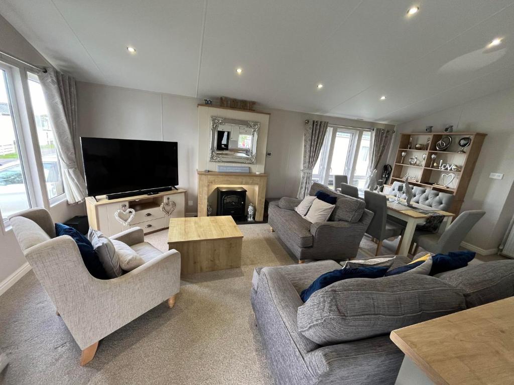 a living room with couches and a flat screen tv at Kestral Court Lodge, Scratby - California Cliffs, Parkdean, sleeps 6, bed linen and towels included, wrap around decking - no pets in Scratby