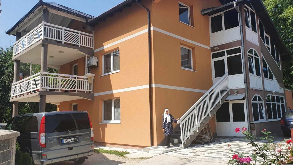 a woman standing on the steps of a building at Kuca in Sarajevo