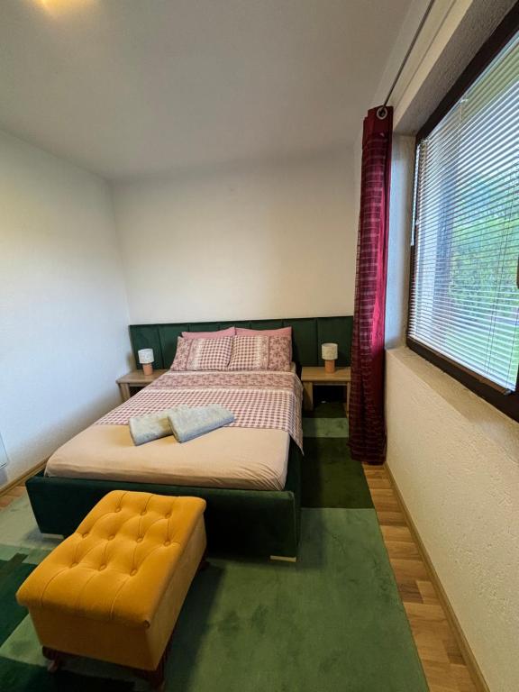 1 dormitorio con 1 cama, 1 silla y 1 ventana en House For Rent en Pristina